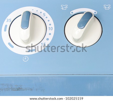White dial on the control panel of wash machine.