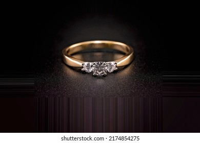 A white diamond trilogy ring representing yesterday today and tomorrow. Three stones set in yellow gold. - Shutterstock ID 2174854275
