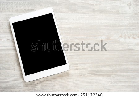 White digital tablet on wooden table