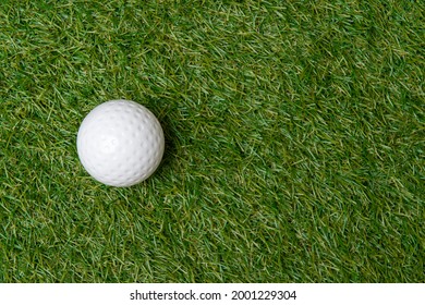 White dimple hockey ball on green grass. Professional sport concept