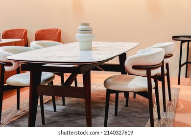 White dining table with white upholstered chairs.