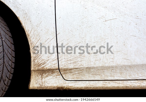 white dirty car in\
the splash of the slurry the driver door and the front fender of\
the vehicle closeup,\
nobody.