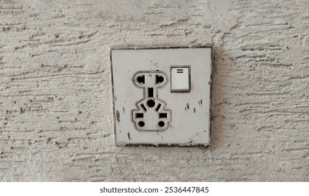 White dirty wall mounted socket board with two electrical sockets and a buttons switch. The socket board is isolated on a white background