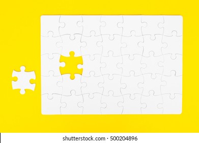 White, disassembled puzzle. On a yellow background.Top view. Flat lay.