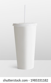 White disposable cup with a plastic lid and a straw