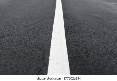 White dividing line perspective over dark asphalt, highway road marking. Abstract transportation background texture