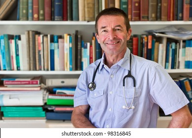 White Doctor In Front Of A Book Shelf Full Of Medical Books