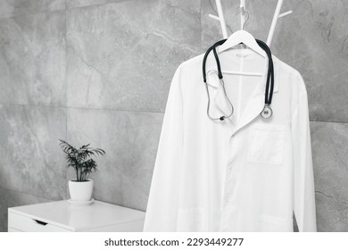 White doctor's gown and stethoscope on rack in clinic