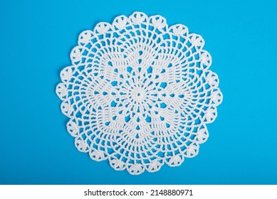 A white doily on a blue background