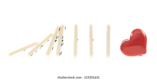 White domino bones pieces falling one after another on to the red glossy heart, composition isolated over the white background - Powered by Shutterstock