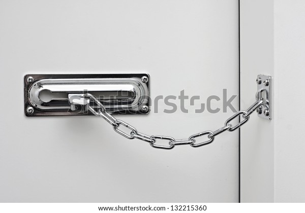 the white door is\
closed on a silvery chain