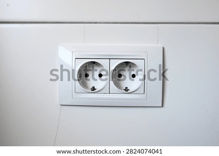 White double Schuko wall socket Type F power outlet. Double electric power socket on a white wall. Modern dual electrical outlet.