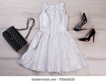 White Dress, Black Handbag And Shoes. Overhead View Of Fashionable Beauty Accessories. Top View Of Leather Black Handbag, Shoes And White Dress.