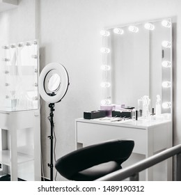 White dressing room with big mirror, lamp and chair. Make up room.