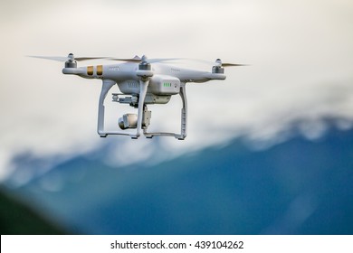 White drone flying above mountains.