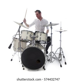 white drummer behind drum set wears white shirt and plays the drums in studio smiling