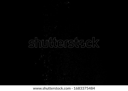 White dust similar to flour and snow is actively scattered isolated on black background