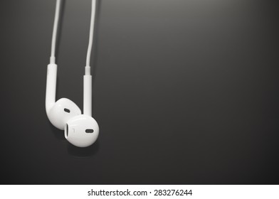 White Earbuds On Black Screen Background