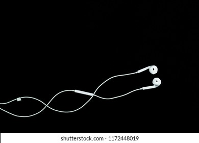 white earphone for listening music on black background - Shutterstock ID 1172448019