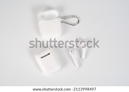 white earphones in a case on a white background