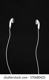 White Earphones On A Black Background.