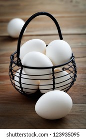 White easter eggs in black wire basket