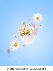 White Easter eggs with spring pear, cosmea and strawberry flowers on blue background. Happy Easter.