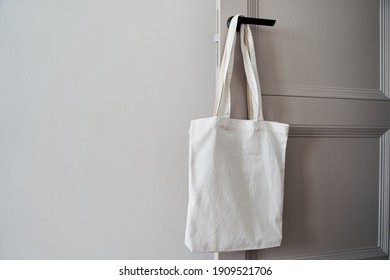 White eco friendly bag hanging on the door handle. Canvas tote bag - Powered by Shutterstock