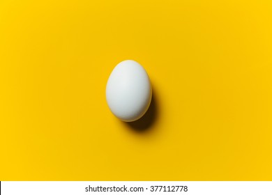 White Egg On The Yellow Background In Center. Design, Visual Art, Minimalism