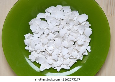 White Egg Shell Chopped Into Small Pieces Is On The Green Plate