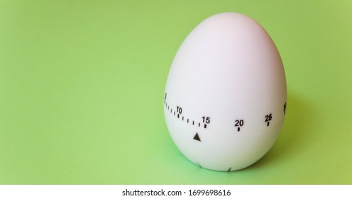 White Egg Timer On Green Background. Happy Easter In The Kitchen. Home Related, Home Staying. Free Copy Space. Flat Lay, Top View. Banner