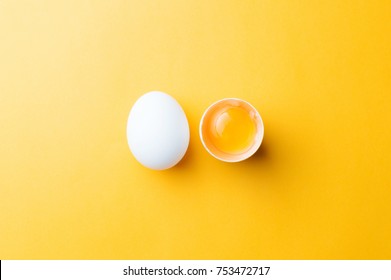 White Egg And Egg Yolk On The Yellow Background.