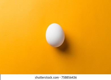 White Egg And Egg Yolk On The Yellow Background.