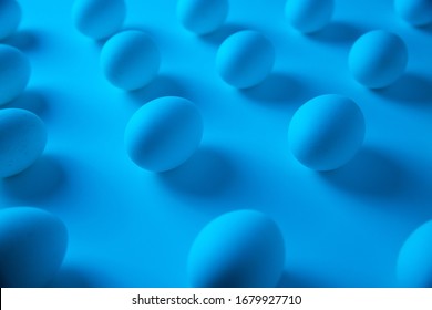 White Eggs Aligned In Rows Lit With Blue Light. Clean Laboratory Concept. Minimalist Abstract Easter Background. Wide Angle Isometric View.