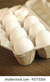 White Eggs In A Carton On A Wooden Table