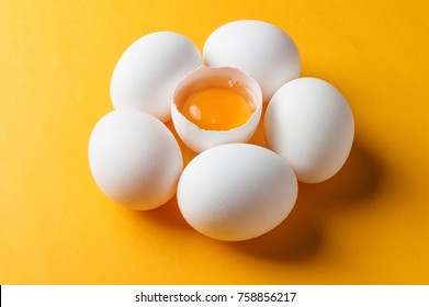 White Eggs And Egg Yolk On The Yellow Background.