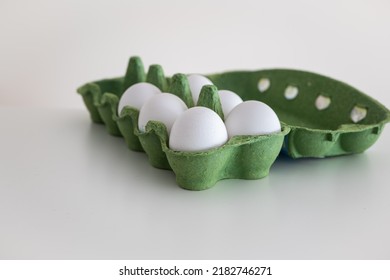 White Eggs In A Green Cardboard Carton, Isolated On White Background, No People.