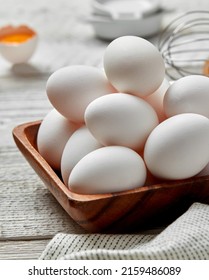 White eggs in wooden bowl close-up
