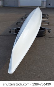 White Eight Sweep Rowing Boat Drying In Upside Down Position At Canal Shore