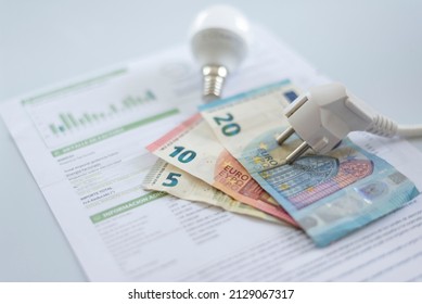 a white electric cap, a light bulb and euro banknotes on an electricity bill. Increase in the cost of electricity . Payment of electricity bills. Increasing the concept of electricity prices.