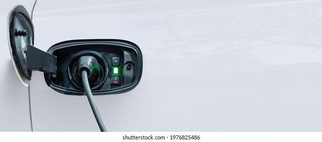 White electric car charging with copy space, Technology electric vehicle concept - Shutterstock ID 1976825486