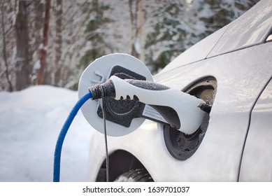 White electric car EV charging during the winter