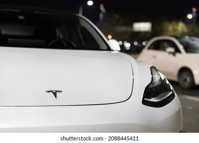 White Electric Car Of Tesla Motors Company. Tesla Company Logo On The Front Bonnet Of Electric Car: Riga, Latvia - September 22, 2021.