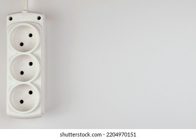 White Electric Power Strip Surge Protector For Three Sockets On A White Background. A Photo