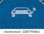 White electric vehicle symbol on blue floor of a charging station