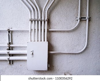 White electrical control junction box for distribution power line on the white concrete wall with copy space - Electricity industrial installation concept