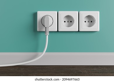 A white electrical outlet on the wall in the room. An electric plug with a cable in the socket. - Shutterstock ID 2094697663