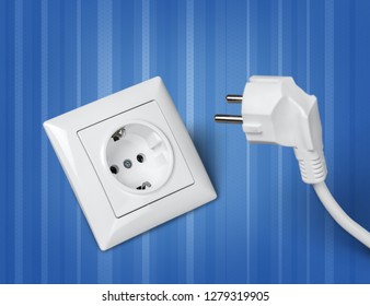 White electrical plug in the electric socket on a wall