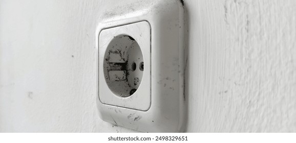 White electrical socket attached to a white painted wall