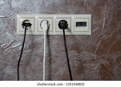 White electrical socket is placed on a wall.